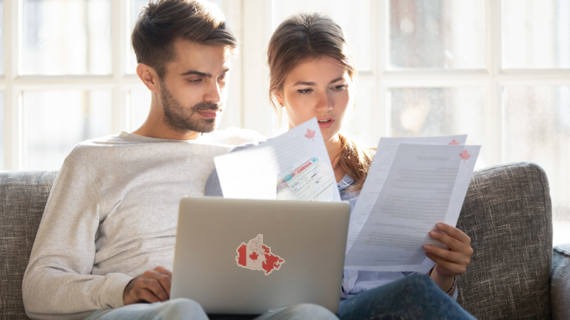 Couple reviewing paperwork for Canadian immigration and work/study permits.